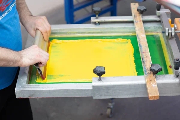Serigraphy sutra layar proses cetak di pabrik pakaian. Frame, squeegee dan cat warna plastisol — Stok Foto