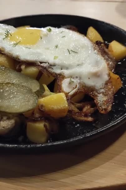 Παραδοσιακό αυστραλιανό τυρολέζικο πιάτο Grostl φτιαγμένο με πατάτα, κρεμμύδι, κόκκο και τηγανητά αυγά. Γάργαρο πιάτο φρέσκο σε τηγάνι — Αρχείο Βίντεο