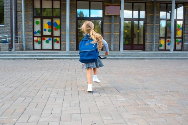 Menina bonito com mochila corre de volta para a escola — Fotografia de Stock