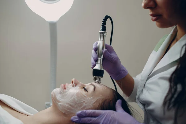 A nő elektromos RF-emelő arcmasszázst kap a szépségszalonban elektroporációs orvosi felszereléssel. Szépség és bőr-egészségügyi koncepció — Stock Fotó