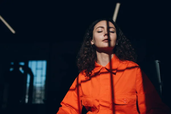 Mujer joven con traje naranja. Mujer en mono de color naranja en la cárcel. —  Fotos de Stock