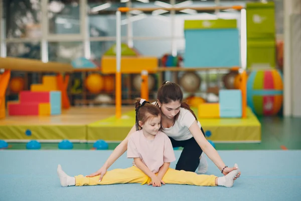 Niños haciendo ejercicios de estiramiento y división en el jardín de infantes o en la escuela primaria. Concepto de deporte y fitness infantil — Foto de Stock