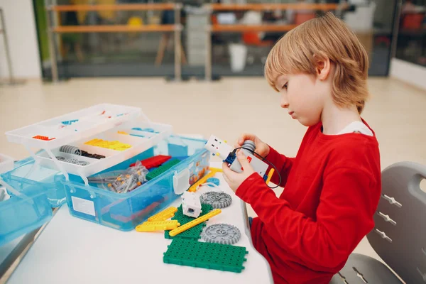 Little boy with robotic constructor assembling technical toy. Children Robotics constructor robot. — Stock Photo, Image