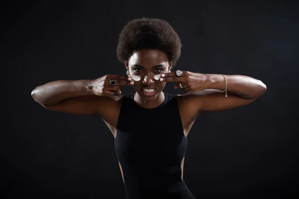 Jeune femme noire afro-américaine appliquant par les doigts crème blanche frottis sur son visage avec émotion joueur de football américain. — Photo