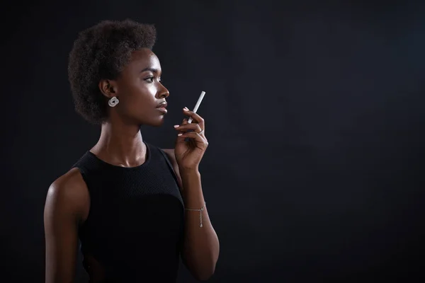Sexy afrykański amerykański kobieta palenie papieros na czarny tło — Zdjęcie stockowe