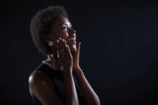 Impressionnante jeune femme afro-américaine à l'expression étonnante et joyeuse admirée, isolée sur fond noir — Photo