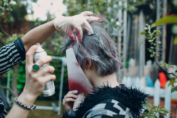 Penata rias tata rias tata rias mewarnai rambut seorang pemuda dengan wajah tertutup dari kaleng aerosol — Stok Foto