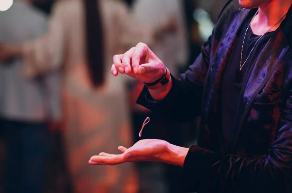 Close up view of magician hand showing focus with flying object rubber band on a hair — Stock Photo, Image