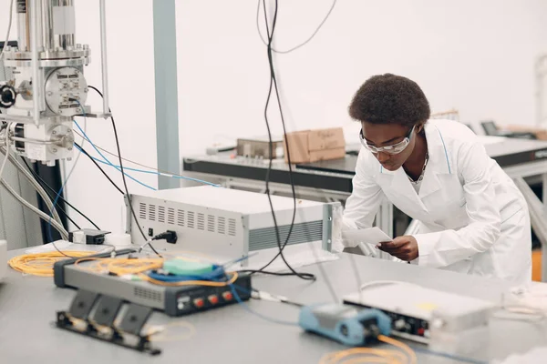 Ilmuwan Afrika Amerika wanita bekerja di laboratorium dengan elektronik instrumen — Stok Foto