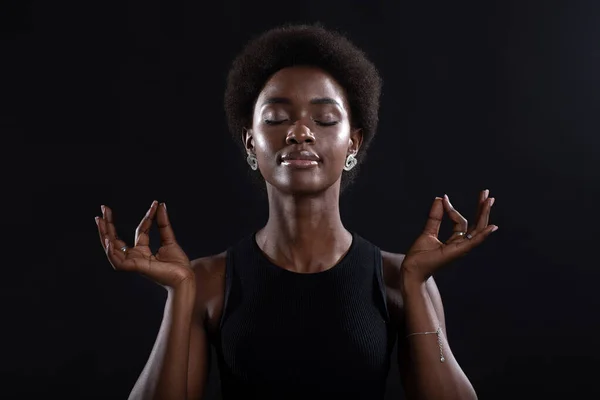 Studioporträt eines afrikanisch-amerikanischen Models mit Zen oder Okay-Zeichen-Geste. Frau meditiert auf schwarzem Hintergrund. — Stockfoto