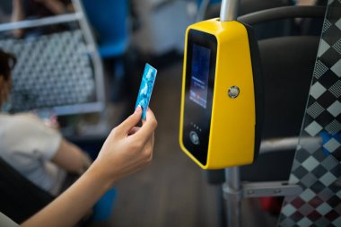 Otobüsteki toplu taşıma için plastik kartla ödeme yapan Asyalı kadın.