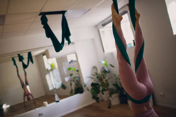 Žena dělá leteckou jógu ve studiu. Samice cvičí jógu v houpací síti — Stock fotografie