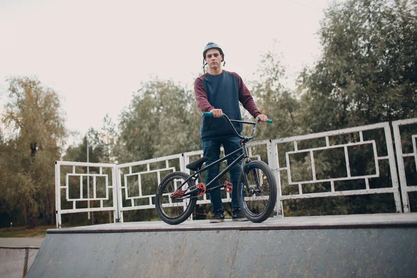 Professionale giovane sportivo ciclista con bici bmx allo skatepark. — Foto Stock