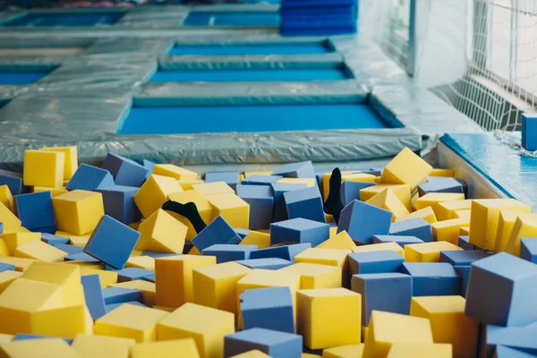 Jeune et belle femme joue dans la piscine sèche avec des cubes — Photo