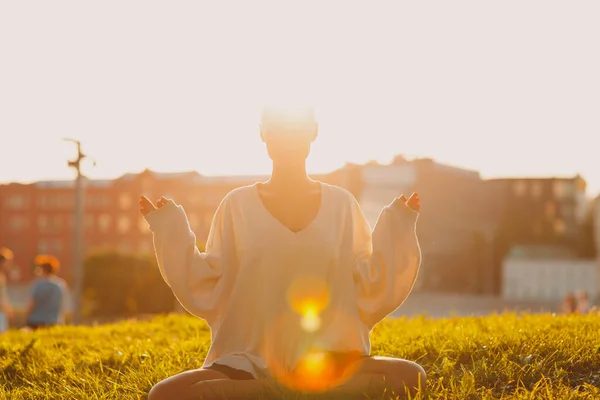 Millenial young woman blonde short hair outdoor doing yoga lotus in park — Stock Photo, Image