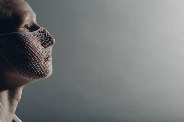 白色高加索白化病女流行模特，头戴检疫医用面罩，灰色背景粗网。Covid-19 Coronavirus保护概念 — 图库照片