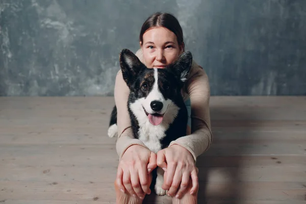 Adulto donna matura che fa yoga a casa in soggiorno con cane da compagnia corgi — Foto Stock