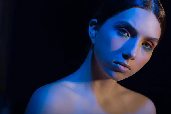 Porträt einer jungen schönen positiven Frau mit nacktem Make-up und buntem Licht — Stockfoto