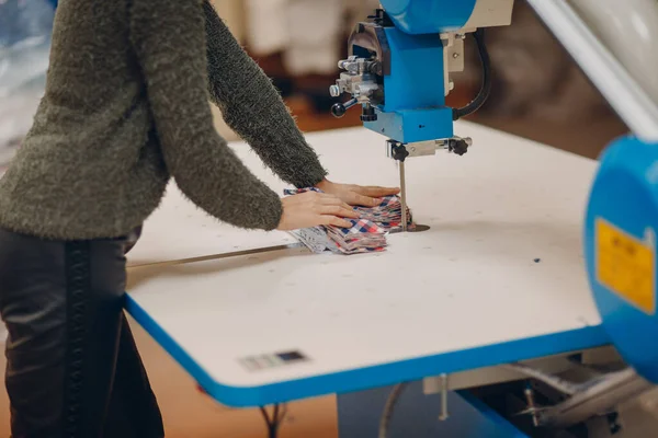 Penjahit muda cantik desainer pakaian memotong kain pada mesin — Stok Foto