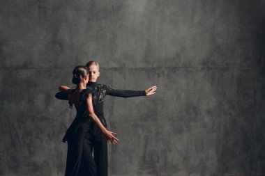 Siyah dans salonundaki genç çift Paso Doble.