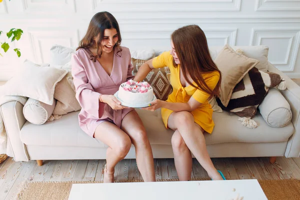 여자들은 집에서 행복 한 친구들이 앉아서 하얀 생일 케이크를 먹는다 — 스톡 사진