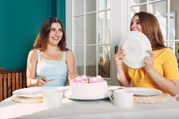 Wanita senang teman-teman di rumah duduk dan tersenyum dengan kue ulang tahun putih — Stok Foto