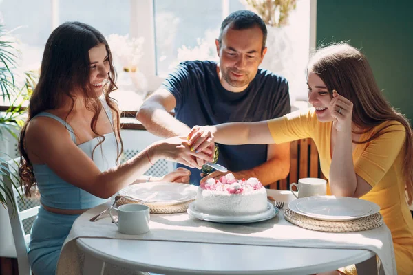 Man en jonge vrouw zitten in huis appartement keuken met taart op tafel en vieren verjaardag — Stockfoto