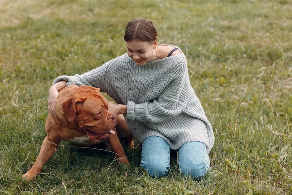 Dogue de Bordeaux o French Mastiff con giovane donna al parco all'aperto — Foto Stock