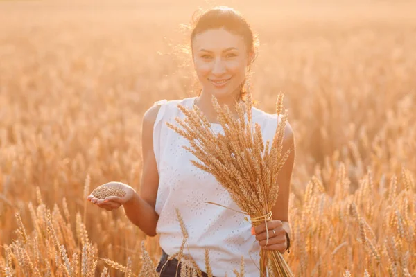 Donna che tiene il covone di spighe di grano a campo agricolo — Foto Stock
