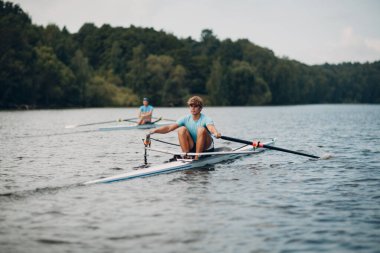 Sporcu, teknede kürek çeken yalnız bir kürekçi.