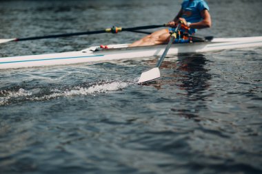 Sporcu, teknede kürek çeken yalnız bir kürekçi.