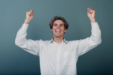 Genç adam neşe içinde ellerini havaya kaldırdı.