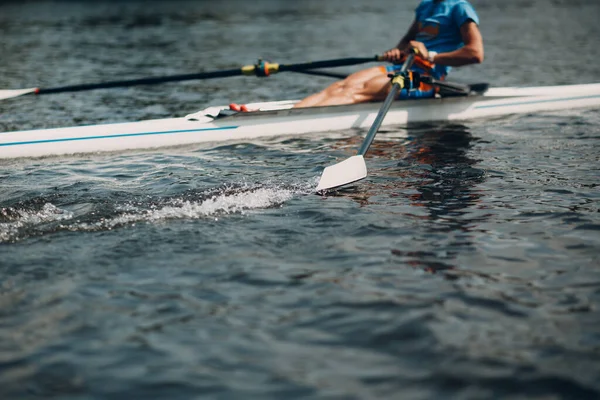 Sportsman single scull man rower rowing on boat