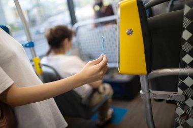 Otobüsteki toplu taşıma için plastik kartla ödeme yapan Asyalı kadın.
