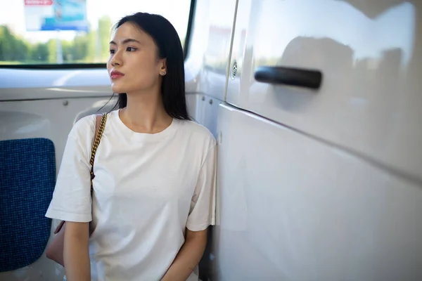 Asiatin fährt in öffentlichen Verkehrsmitteln Bus oder Straßenbahn. — Stockfoto