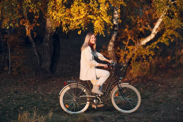 Felice attiva giovane donna in bicicletta nel parco autunnale — Foto Stock