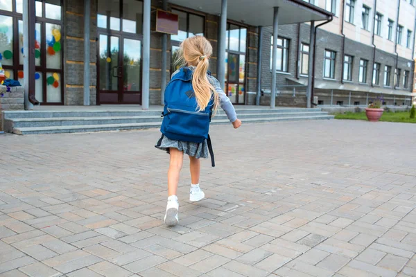 Söt liten flicka med ryggsäck som springer tillbaka till skolan — Stockfoto