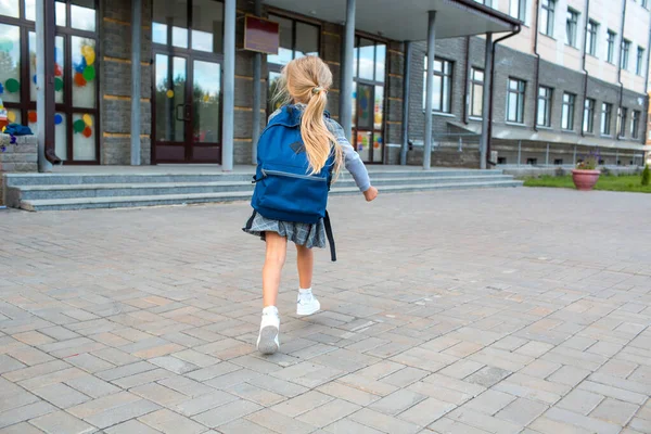 Schattig klein meisje met rugzak loopt terug naar school — Stockfoto