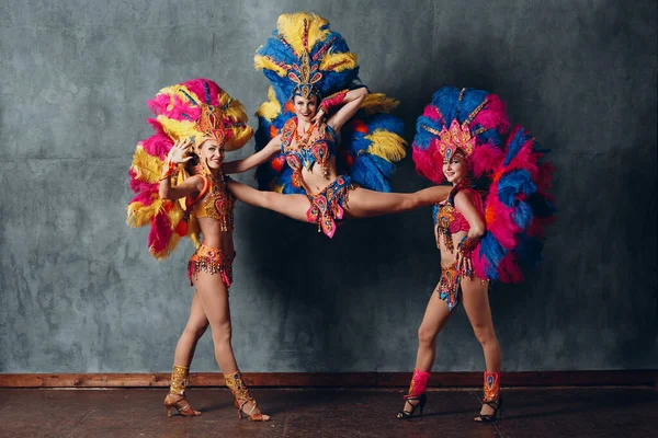 Trzy kobiety w brazylijskim stroju karnawałowym samba z kolorowymi piórami upierzenie — Zdjęcie stockowe