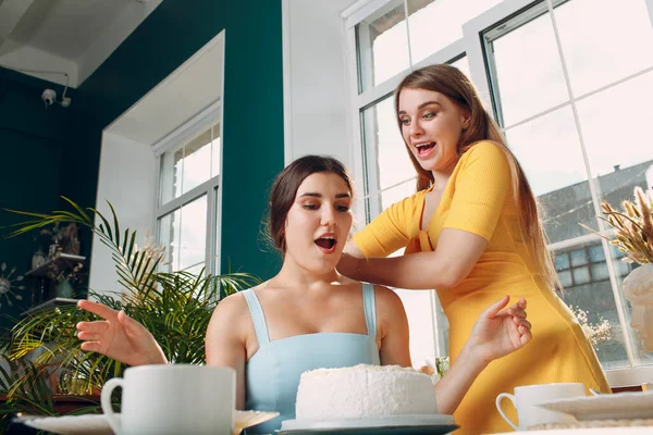 Wanita muda dips wajah dalam kue putih dengan krim. Selamat ulang tahun konsep. — Stok Foto
