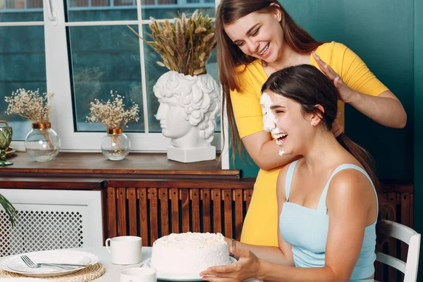 Wanita muda dips wajah dalam kue putih dengan krim. Selamat ulang tahun konsep. — Stok Foto