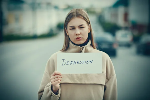 Wanita memegang lembaran putih kertas berlabel Depresi kata di tangan. — Stok Foto