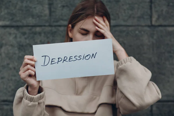 Gadis memegang selembar kertas dengan Depresi kata — Stok Foto