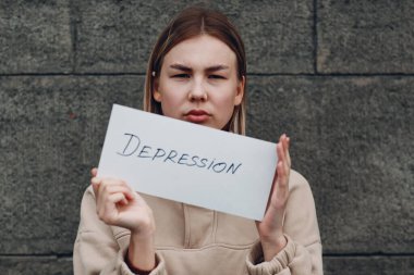 Kadın, el kâğıdında kelime buhranı tutuyor.