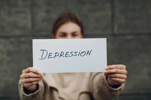 Gadis memegang selembar kertas dengan Depresi kata — Stok Foto