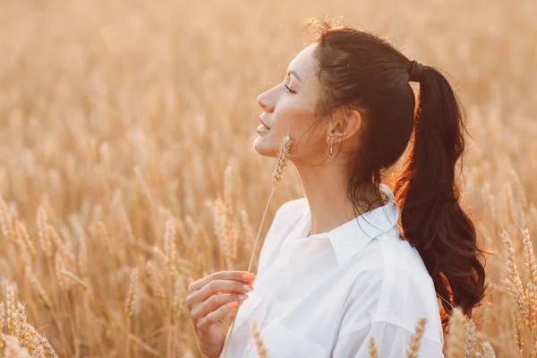 Ritratto di una bella donna bruna con spighe di grano sul viso — Foto Stock