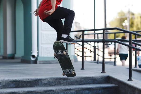 Young boy riding trick on skateboard in city — Stock Photo, Image