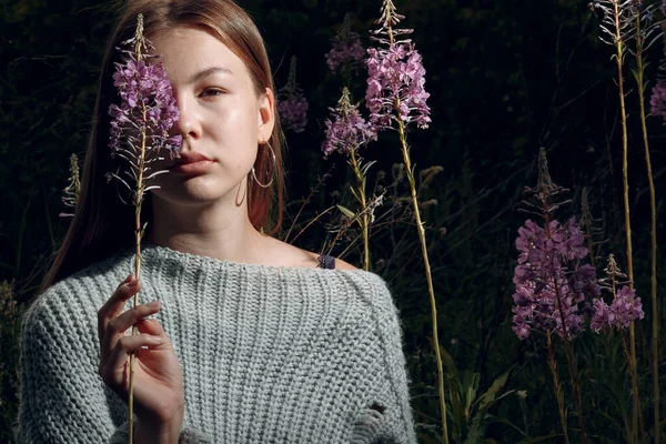 Bella giovane donna all'aperto nel parco con fiori estivi — Foto Stock