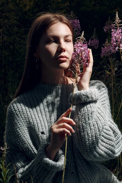 Bella giovane donna all'aperto nel parco con fiori estivi — Foto Stock