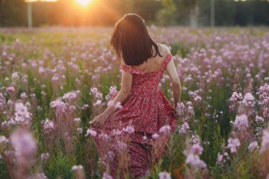 Sally 'nin çiçek tarlasında gün batımında çiçek açan kız. Leylak çiçekleri ve kadın.